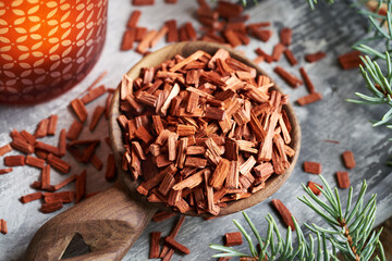 Red sandalwood chips on a spoon with a candle