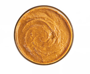 Overhead View of a Bowl of Smooth Peanut Butter on a White Background