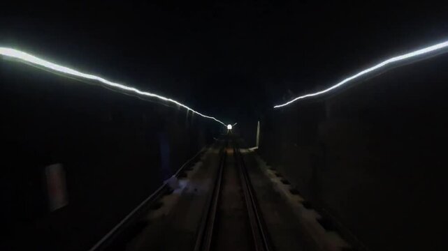 Rear view of an Indonesian train in a long dark tunnel,the longest active railway tunnel in Indonesia,Sasaksaat tunnel