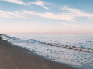 Peaceful beach at dusk with blue and pink skies
