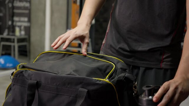 Taking Out Whey Protein and Shaker Bottle from Gym Bag. Person unpacking whey protein and a shaker bottle from a gym bag, ideal for fitness nutrition and supplement-related content.