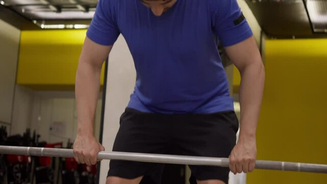 Man Lifting Barbell in Gym for Strength Training. Focused man performing barbell exercises, ideal for fitness and strength training content.