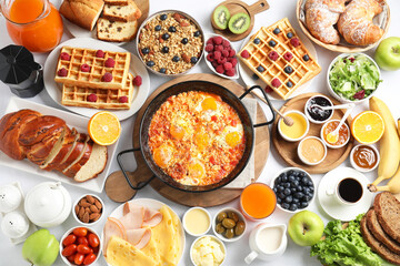 Different meals served for breakfast on white table, flat lay