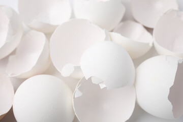 Pieces of broken eggshells on white background, closeup