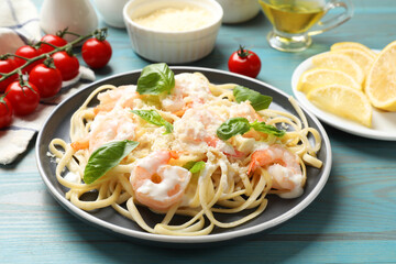 Tasty pasta with shrimps on light blue wooden table, closeup