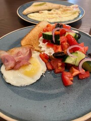 Scrambled eggs with bacon, vegetables and toast