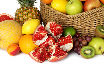 Many different fresh fruits in wicker basket isolated on white