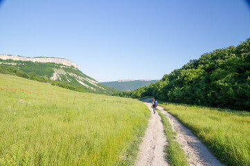 Tourist with backpacks are traveling along a mountain path