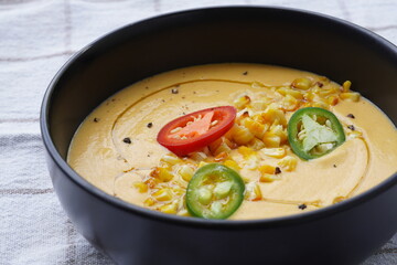 Vegetable cream soup with corn, chillies and olive oil. Close-up.