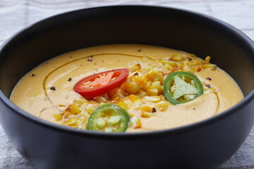 Vegetable cream soup with corn, chillies and olive oil. Close-up. of bowl.