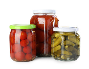 Tasty pickled tomatoes and cucumbers in jars isolated on white