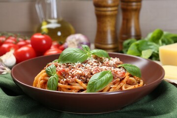 Delicious pasta bolognese with basil on table, closeup