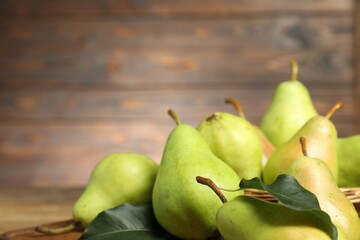 Fresh green pears and leaves on table, closeup. Space for text