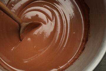Chocolate dough and spoon in bowl, closeup