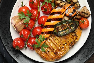 Delicious grilled vegetables and chicken breast on table, top view