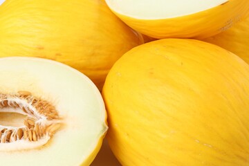 Whole and cut ripe melons as background, closeup