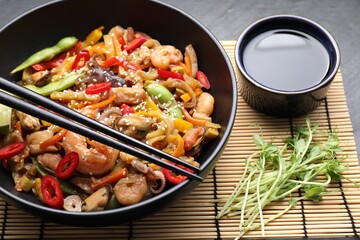 Stir-fry sea food served on grey table, closeup