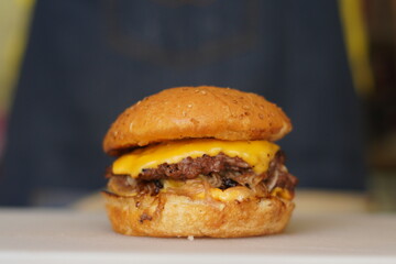 Cheeseburger with onions and melted American cheese. Close-up.