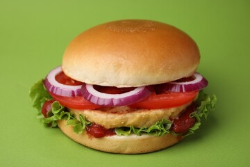 Delicious vegan burger with chickpea cutlet on green background