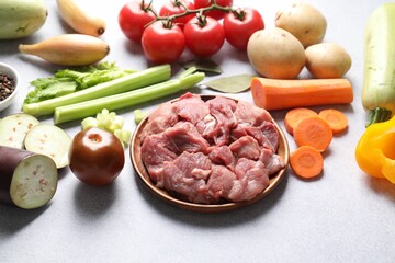Cooking stew. Uncooked meat and vegetables on light grey table
