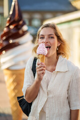 Blond girl having pink ice cream cone on sunny day at sweden gothenburg