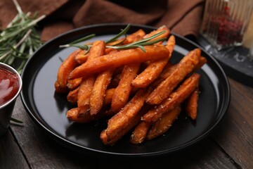 Sweet potato fries and rosemary on wooden table, closeup