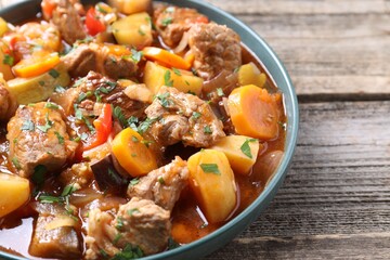 Delicious stew with vegetables on wooden table, closeup