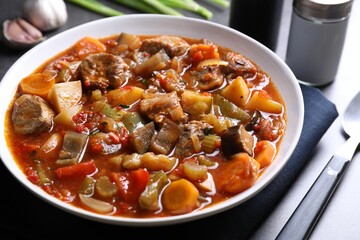 Delicious stew with vegetables in bowl on table, closeup