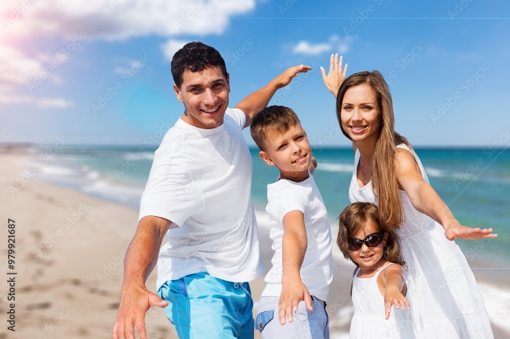 Wall mural a joyful young family enjoys time on beach.