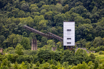 Abandoned Industrial Mining Structure with Conveyor Belt in Forested Area.