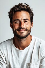 Obraz premium A cheerful young man with a relaxed expression looks at the camera, showcasing a friendly demeanor