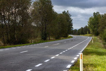 A winding road through lush greenery under an overcast sky.