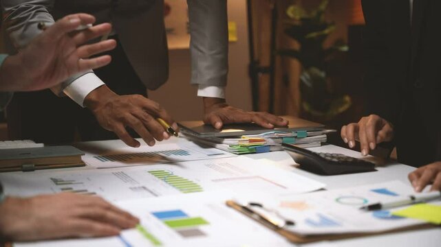 Business Strategy: Close-up of hands working collaboratively on a project, analyzing data and charts with focus and determination. This image conveys the essence of teamwork, problem-solving, and stra