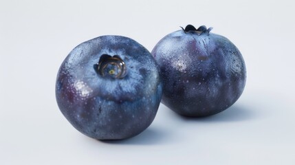Two ripe blueberries sit side by side on a surface