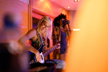 Diverse female band members recording in a music studio together