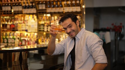 Smiling smart man drinking cocktail in Old fashioned with enjoy dancing in cheers with friends or stranger special vibrant beverage at nightclub on Friday meeting at luxurious counter bar. Vinosity.