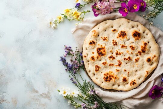 Flatbread with edible flowers on white background