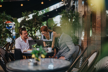 Group of businesspeople collaborating at an outdoor cafe, discussing ideas and working on a laptop in a relaxed and green environment.