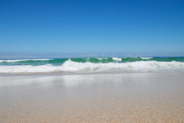 Welle am Strand bei blauem Himmel