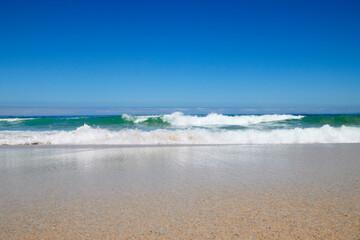 Welle am Strand bei blauem Himmel