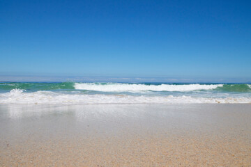 Welle am Strand bei blauem Himmel