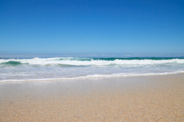 Obraz premium Welle am Strand bei blauem Himmel