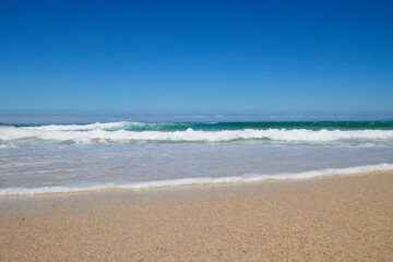 Welle am Strand bei blauem Himmel