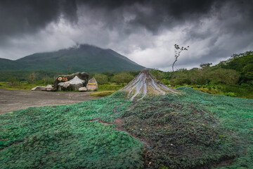 Model of Arenal volcano next to the reals Arenal volcano hiding in the clouds