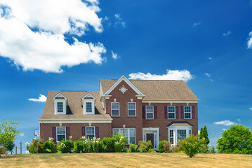  large country house under blue skies. Landscape with garden design, lawn and clouds.