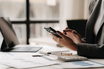 Fototapeta premium Mobile Strategy Session: Businesswoman Analyzing Data on Smartphone in Modern Office 