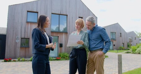 Real estate Agent giving Property details of an new for Sale Home to a Mature Couple