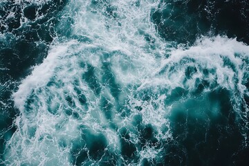 Fototapeta premium Aerial view of ocean waves crashing with white foam, blue and green water texture background