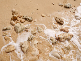 Seashore with a set of pebbles on sandy beach