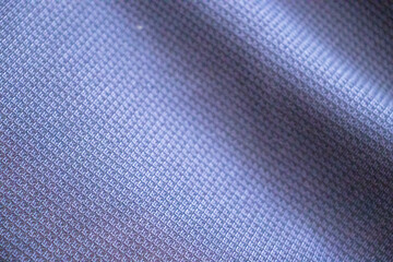 Close-up of a textured fabric in soft hues of blue, showcasing intricate patterns and textures, ideal for backgrounds or textile design